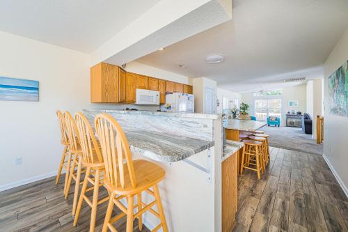 a kitchen with wooden chairs and a counter top at Follow the Sun in Duck