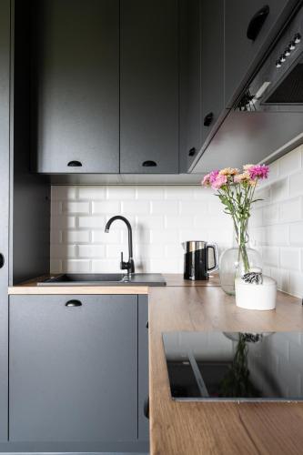 a kitchen with a sink and a vase of flowers at Jedla Apartments in Dzianisz