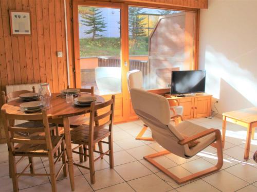 une salle à manger avec une table, des chaises et une télévision dans l'établissement Appartement 2 Pièces Coin Montagne, Terrasse Sud, Parking Privé, Proche Centre et Pistes à Vars Les Claux - FR-1-330B-64, à Vars