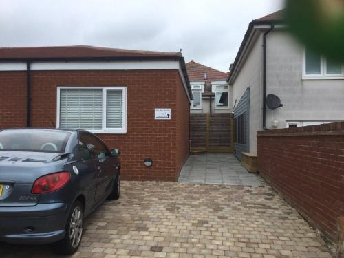 a car parked in front of a brick house at The Bay Studio 1 in Broadstairs