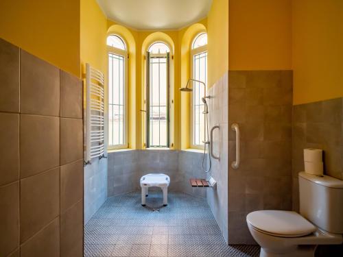 une salle de bain avec des murs jaunes et des toilettes et des fenêtres dans l'établissement BANANA'S CAMP, à Cannes