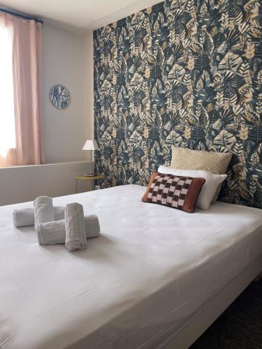 a bed with two towels on it in a bedroom at Hôtel Clair de Lune in Mauguio