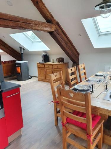 une cuisine avec une table et des chaises dans une pièce dans l'établissement Gite le cerf 8 personnes + 1 bebe, à Raon-aux-Bois