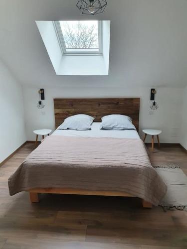 - une chambre avec un grand lit et 2 tables dans l'établissement Gite le cerf 8 personnes + 1 bebe, à Raon-aux-Bois