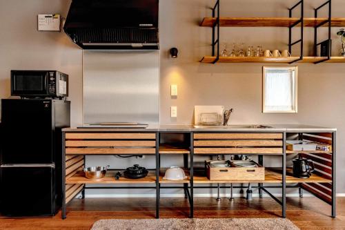 a kitchen with a counter and a refrigerator at Rakuten STAY HOUSE x WILL STYLE Hachimanbori in Omihachiman