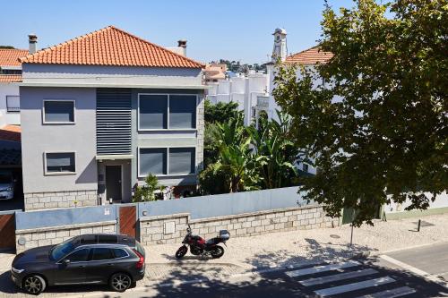 a motorcycle and a car parked in a parking lot at Eco Ljmonade Hostel in Cascais