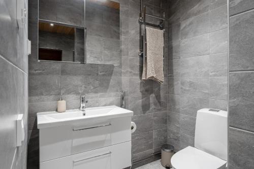 a bathroom with a white sink and a toilet at "Keskustori" - Renovated 1BR Apartment with Sauna at the BEST Location, Hosted by 2ndhomes in Tampere