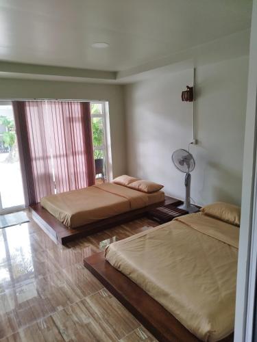 a bedroom with two beds and a fan at WHITE SAND ARK RESORT in Koh Rong Island