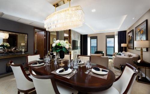 a dining room with a wooden table and chairs at The Elysium Prațumnak Pattaya - By SHG in Pattaya South