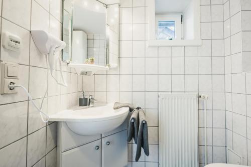 a white bathroom with a sink and a mirror at Stral-Sund in Stralsund