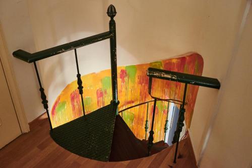 a black umbrella hanging on a wall with a painting at Eco Ljmonade Hostel in Cascais