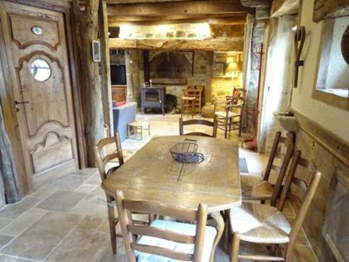 a dining room with a wooden table and chairs at Gite du tailleur in Sébrazac