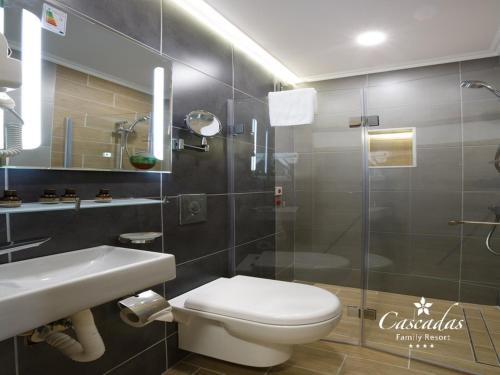 a bathroom with a toilet and a sink and a shower at Cascadas Family Resort in Sunny Beach