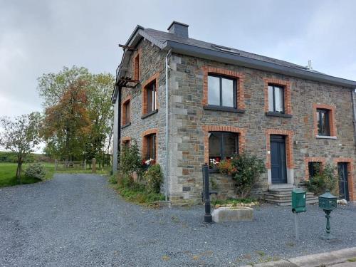 a brick house with a parking meter in front of it at Le Reposoir Maison spacieuse avec feu au bois in Bertogne