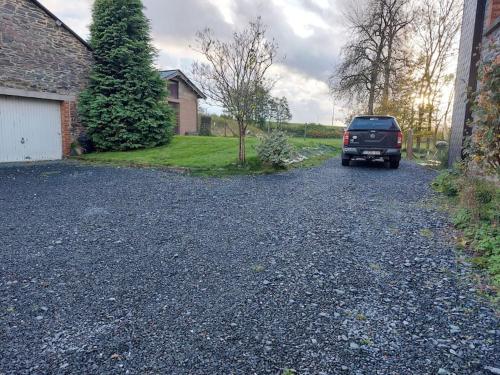 a truck parked on a gravel road in a driveway at Le Reposoir Maison spacieuse avec feu au bois in Bertogne