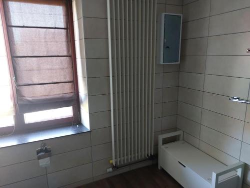 a bathroom with a radiator and a window and a bench at Le Reposoir Maison spacieuse avec feu au bois in Bertogne