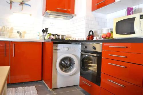 cocina con armarios rojos y lavadora en Apprt Top Center / 2 Chambres / 2 Salles de bain., en Montpellier