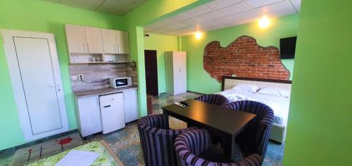 a room with a bed and a table and chairs at Стаи, студиа и апартаменти in Svishtov