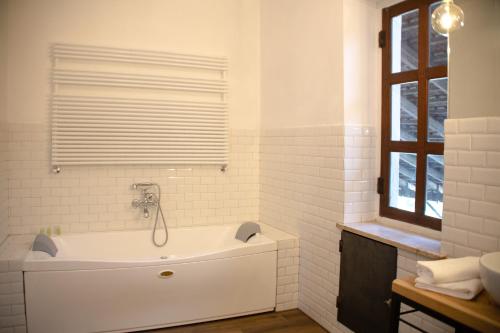 a white bathroom with a tub and a window at Agriturismo La Margherita in Carmagnola