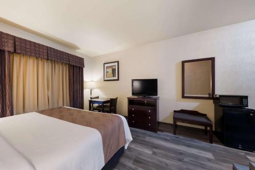 a hotel room with a bed and a television at Quality Inn & Suites Terrell in Terrell