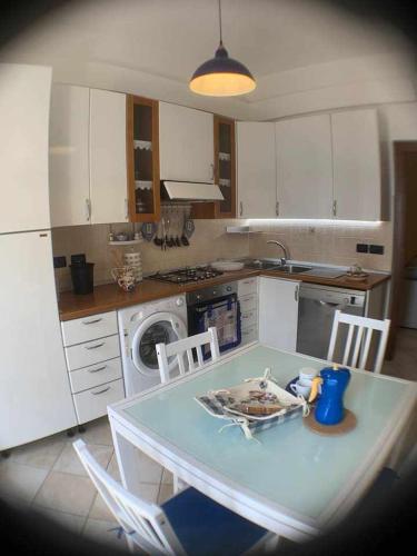 a kitchen with a table and chairs and a sink at Appartamento sul porto Nettuno in Nettuno
