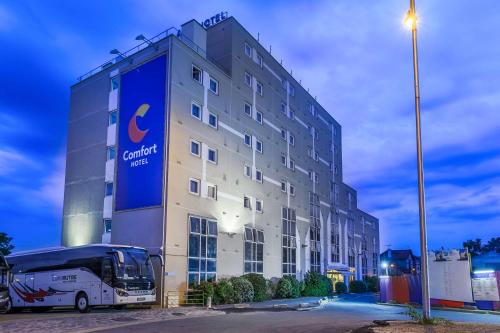 um edifício com um autocarro estacionado em frente em Comfort Hotel Paris Porte d'Ivry em Ivry-sur-Seine