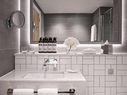 a white bathroom with a sink and a mirror at Hyatt Regency Manchester in Manchester