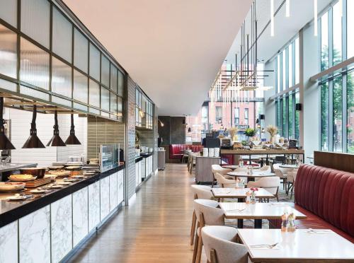 un restaurante con mesas, sillas y ventanas en Hyatt Regency Manchester en Mánchester