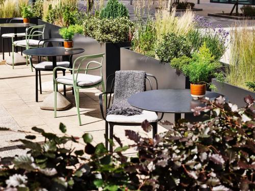 a patio with tables and chairs and plants at Hyatt Regency Manchester in Manchester
