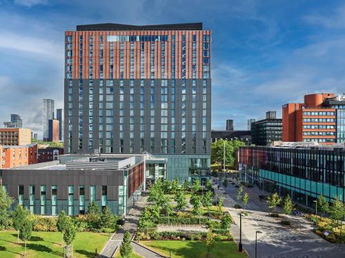 a tall building in the middle of a city at Hyatt Regency Manchester in Manchester