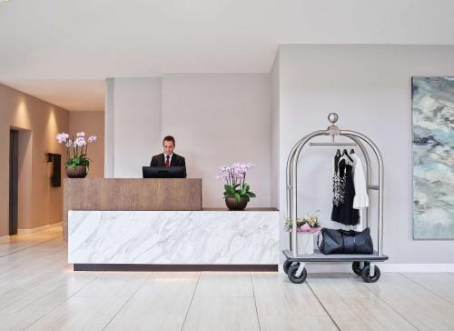 a man in a suit standing at a reception desk at Hyatt Regency Manchester in Manchester