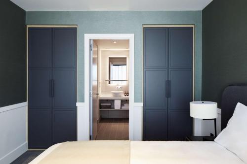 a bedroom with a bed and a bathroom with a sink at Hyatt House Manchester - Aparthotel in Manchester