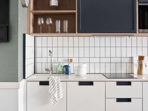 a kitchen with white cabinets and a counter top at Hyatt House Manchester in Manchester