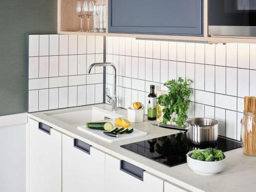 a kitchen counter with a sink with vegetables on it at Hyatt House Manchester - Aparthotel in Manchester