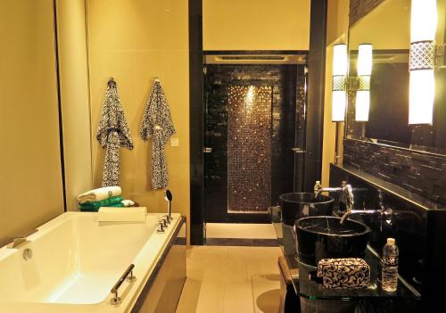a bathroom with a tub and a sink and a shower at Banyan Tree Samui - SHA Extra Plus in Lamai