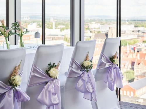 a table with white chairs with flowers on them at Hyatt House Manchester - Aparthotel in Manchester