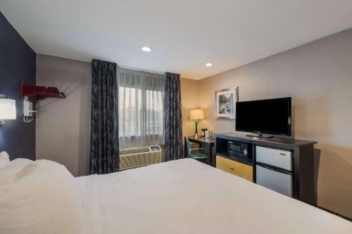 a hotel room with a bed and a flat screen tv at Quality Inn - Denton in Denton