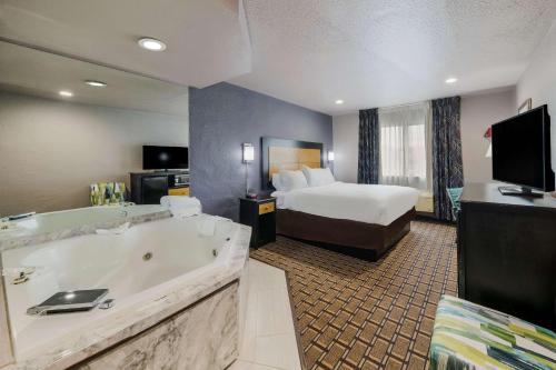 une chambre d'hôtel avec une grande baignoire et un lit dans l'établissement Quality Inn - Denton, à Denton