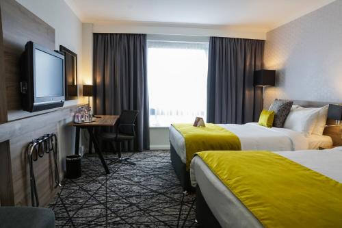 a hotel room with two beds and a flat screen tv at Crowne Plaza Liverpool City Centre, an IHG Hotel in Liverpool