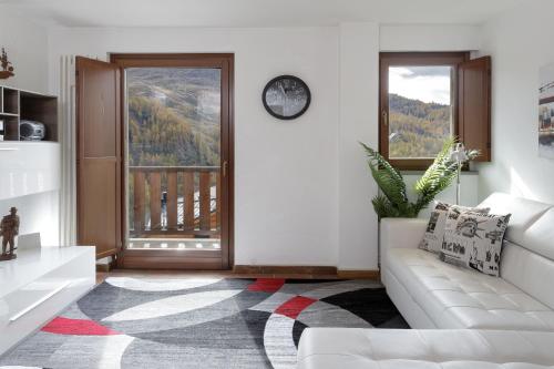 - un salon avec un canapé et une grande fenêtre dans l'établissement HelloChalet - Maison Skis Aux Pieds - ski-in with boot warmer and garage, à Breuil-Cervinia