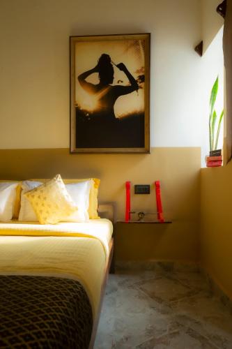 a bedroom with two beds and a picture on the wall at Craft Hostels in Anjuna
