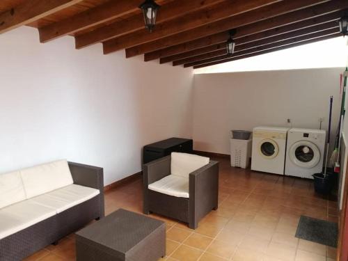 een woonkamer met een bank en een wasmachine bij Idílico adosado en El Mocanal in Mocanal