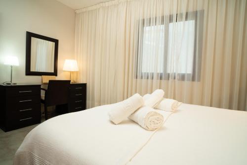 a bedroom with a white bed with three pillows at Holiday House Penthouse in La Gomera in San Sebastián de la Gomera