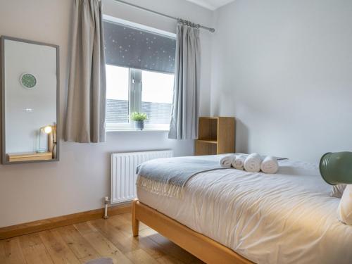a bedroom with a bed with a mirror and a window at Gorgeous 3BR Townhouse with Garden South Belfast - Pass the Keys in Belfast