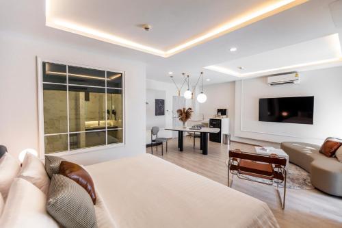 a bedroom with a bed and a living room at R2 Hotel Chiangmai in Chiang Mai