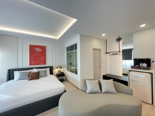 a bedroom with a bed and a couch at R2 Hotel Chiangmai in Chiang Mai