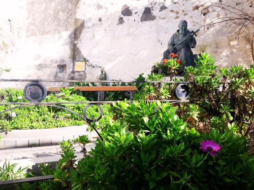 a statue of a man with a gun in a garden at Maison Escher in Atrani