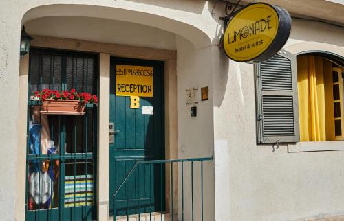 budynek z zielonymi drzwiami i znakiem na nim w obiekcie Ljmonade Hostel w mieście Cascais