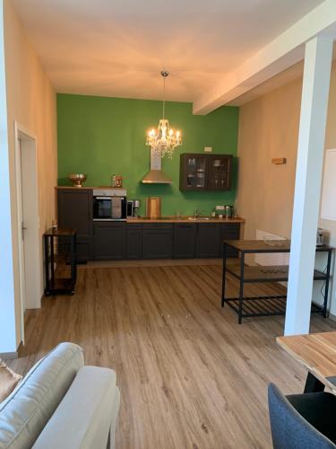 a living room with a couch and a kitchen at Ferienwohnung 2 am Herrenhaus Ahrensbök in Ahrensbök
