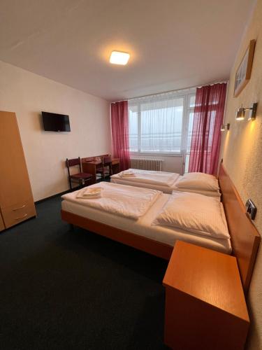 ein Hotelzimmer mit einem großen Bett und einem Tisch in der Unterkunft Hotel Labe in Leitmeritz